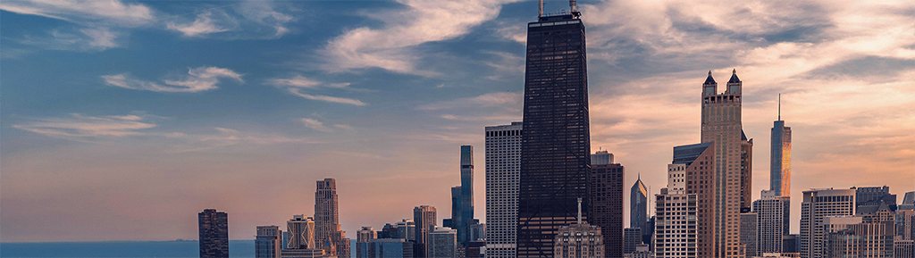 Photograph of the Chicago skyline at sunset, looking south with Hancock Tower near center of frame
